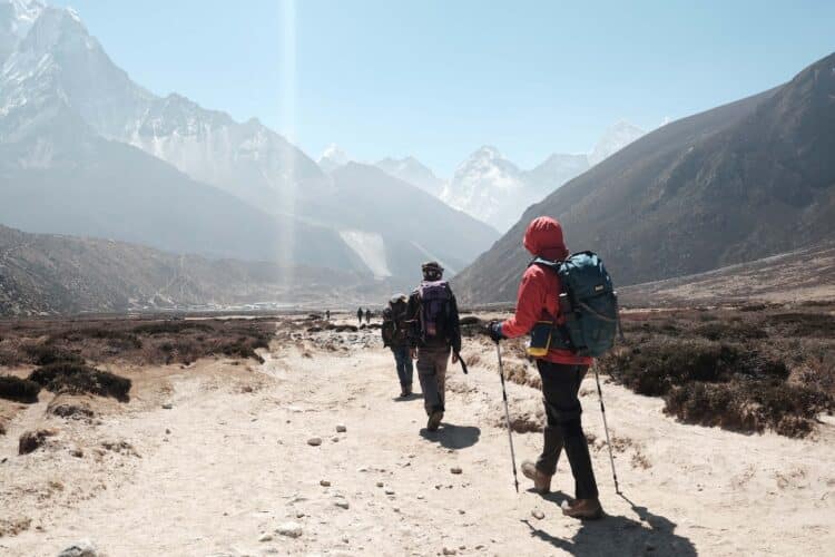 people hiking towards mountain ranges