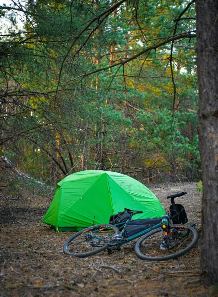 a tent and bicycles in a forest